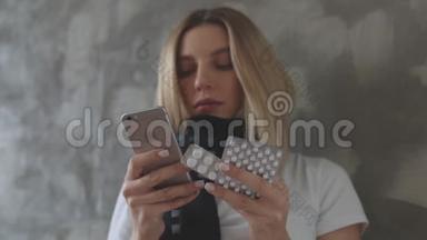 一个女人一只手拿着手机，另一只手拿着一簇平板电脑，站在灰色的背景下。 一个女孩